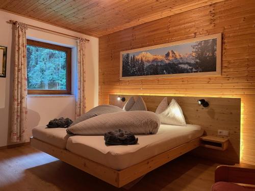 a bedroom with a bed in a wooden wall at Garni Bärenwirt in Leutasch