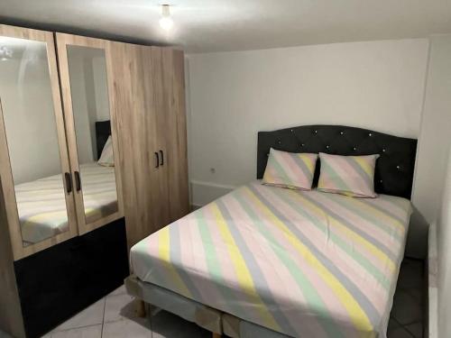 - une chambre avec un lit et un miroir dans l'établissement Appartement en plein centre ville du bourget, au Bourget