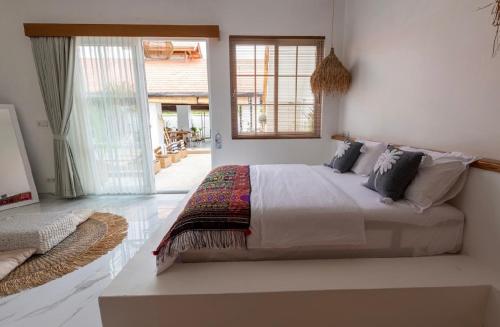 a bedroom with a large bed and a large window at Keramas Moonlight Villa in Keramas