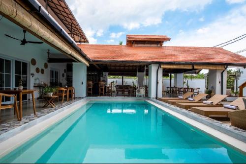 a swimming pool with a pavilion and a house at Keramas Moonlight Villa in Keramas
