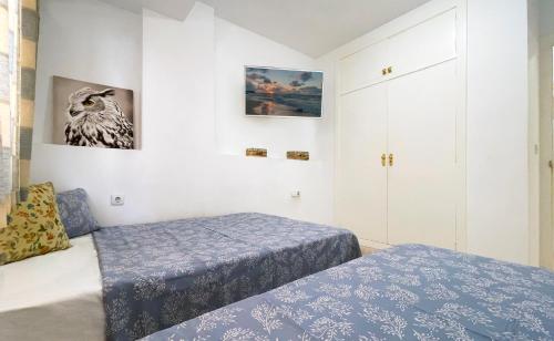 een slaapkamer met twee bedden en twee foto's aan de muur bij Jardín en el centro de Calpe in Calpe