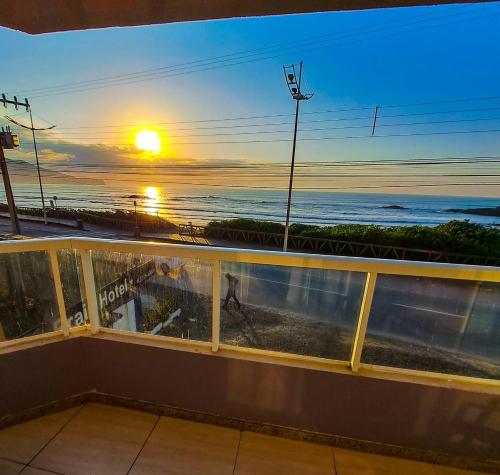 a view of the ocean from a balcony at sunset at Gravatá Praia Hotel- Frente ao mar in Navegantes
