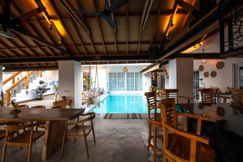 a living room with a pool and tables and chairs at Keramas Moonlight Villa in Keramas