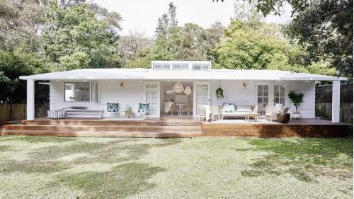 a white house with a porch and a deck at Pearl Beach Shack, walk to beach, pet friendly in Pearl Beach