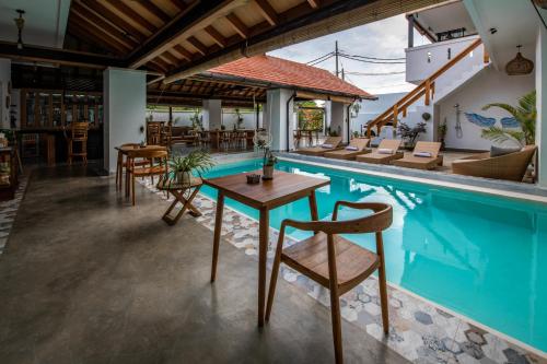 a poolside restaurant with a table and chairs next to it at Keramas Moonlight Villa in Keramas