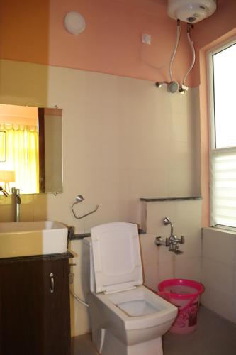 a bathroom with a white toilet and a sink at Da Mantra House in Tiruvannāmalai