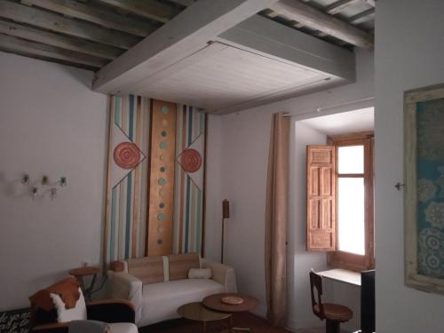 a living room with a white couch and a window at La gota de leche 3 in Sanlúcar de Barrameda
