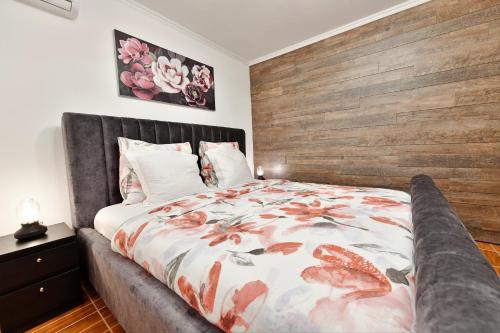 a bedroom with a large bed with a wooden headboard at Apartments Green Park in Rakovica