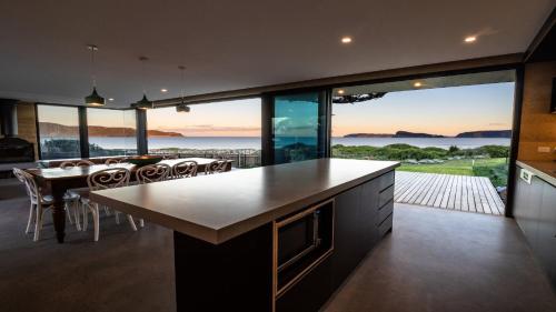 a kitchen with a large view of the ocean at Ocean Beach Pavilion - Beachfront in Umina