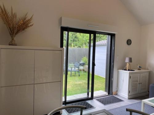 une chambre avec une porte coulissante en verre et une cour dans l'établissement TAMA, à Saint-Lunaire