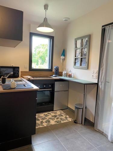 une cuisine avec une cuisinière et un comptoir dans l'établissement TAMA, à Saint-Lunaire