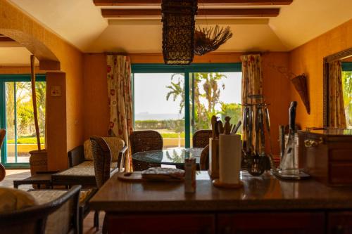 a dining room with a table and a large window at Ras Sedr Royal Beach Villa at Sinaway Lagoon Hotel & Spa- Ras Sedr, Egypt in Ras Sedr