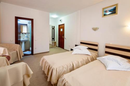 a hotel room with two beds and a bathroom at Suior Resort Baza in Baia-Sprie