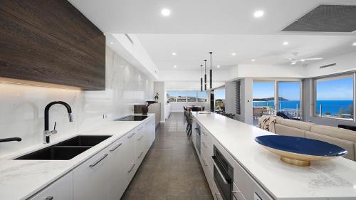 a large white kitchen with a blue bowl on the counter at Amazing Views and Short Walk To Beach in Terrigal