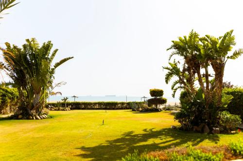 a golf course with palm trees and the ocean in the background at Ras Sedr Royal Beach Villa at Sinaway Lagoon Hotel & Spa- Ras Sedr, Egypt in Ras Sedr