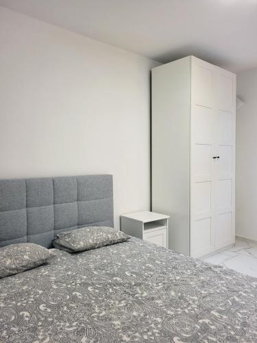 a bedroom with a bed and a white cabinet at Stara Pošta Apartment 1 in Grosuplje