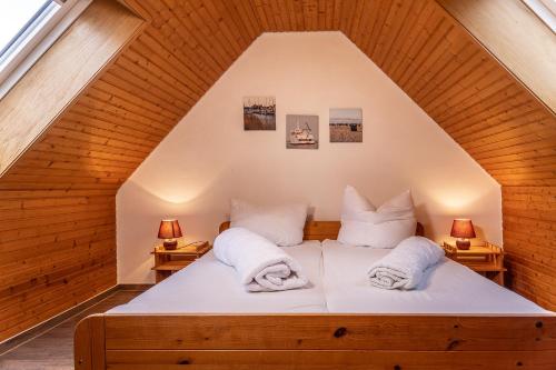 a bed with white pillows on it in a attic at 50041 Muschelbank in Harlesiel