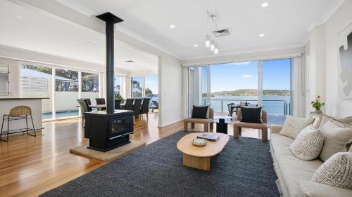 a living room with a couch and a fireplace at Waters Edge - Point Clare - Pool - Spa - Private Jetty in Point Clare