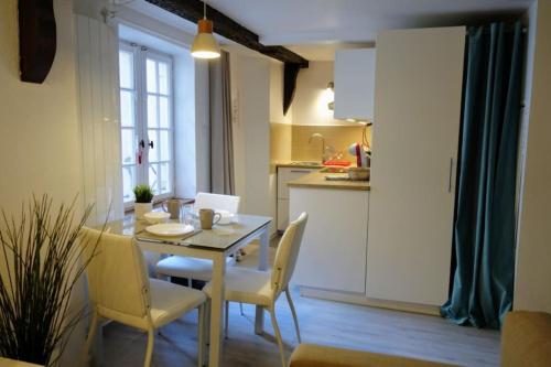 une petite cuisine avec une table et des chaises dans une pièce dans l'établissement Le Finkwiller - Cosy studio au coeur de Strasbourg, à Strasbourg