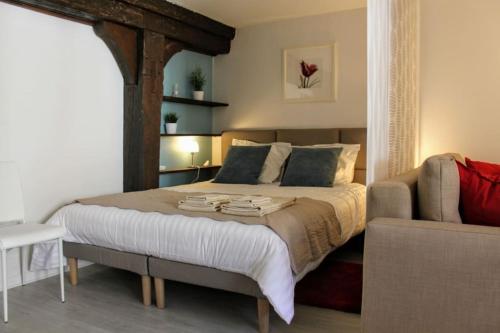 une chambre avec un grand lit et un canapé dans l'établissement Le Finkwiller - Cosy studio au coeur de Strasbourg, à Strasbourg