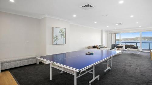 a living room with a ping pong table in it at Waters Edge - Point Clare - Pool , Spa, Private Jetty in Point Clare