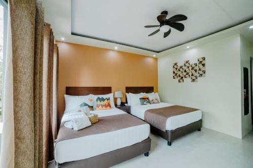 a bedroom with two beds and a ceiling fan at Spacio Caliraya Bed & Breakfast in Lumban