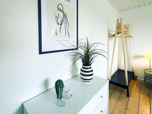 a white cabinet with a vase on top of it at Modern apartment for 6 in city center in Aalborg