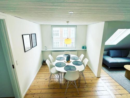 a room with a table and chairs and a couch at Modern apartment for 6 in city center in Aalborg