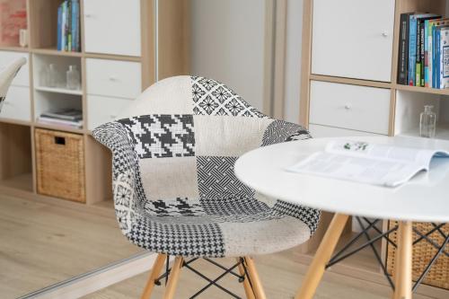 a chair with a quilt on it next to a table at Hetmańska Comfy Studio Poznań by Renters in Poznań
