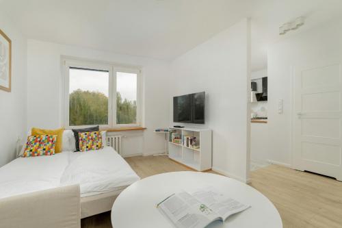 a white room with a bed and a table at Hetmańska Comfy Studio Poznań by Renters in Poznań