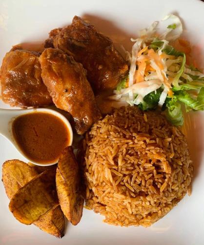 a plate of food with rice and vegetables and sauce at Bojo Beach Resort in Bortianor