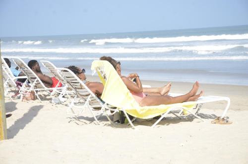 a group of people sitting in lawn chairs on the beach at Bojo Beach Resort in Bortianor