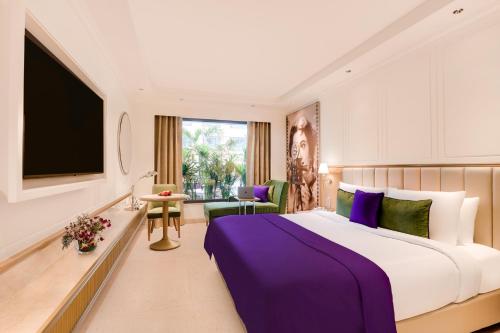 a hotel room with a large bed and a tv at Aurika, Mumbai International Airport - Luxury by Lemon Tree Hotels in Mumbai