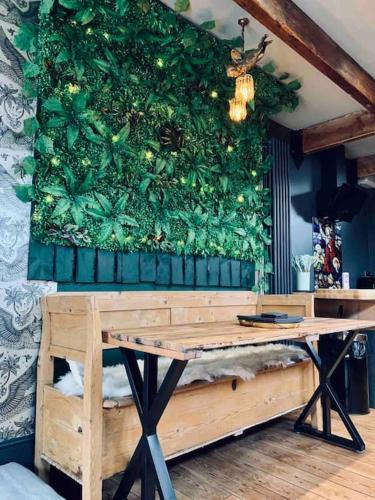 a green wall with a wooden table in a room at Chapter Two - Melbourne in Melbourne