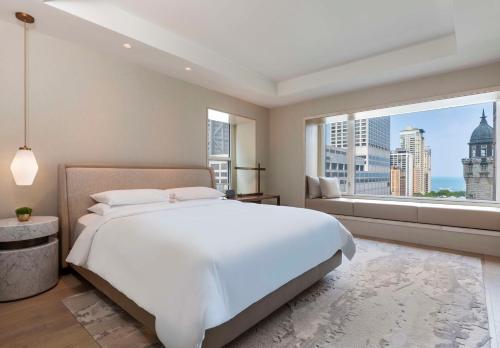 a bedroom with a large white bed and a large window at Park Hyatt Chicago in Chicago