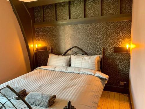 a bedroom with a bed and two lights on the wall at Chapter Two - Melbourne in Melbourne