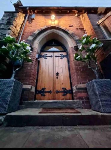 an entrance to a brick building with a wooden door at Chapter Two - Melbourne in Melbourne