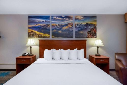 a hotel room with a bed with three paintings on the wall at Days Inn by Wyndham Casper in Casper