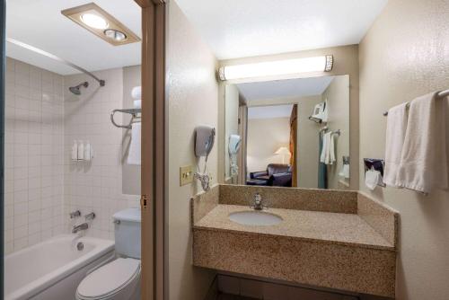 a bathroom with a sink and a toilet and a mirror at Days Inn by Wyndham Casper in Casper