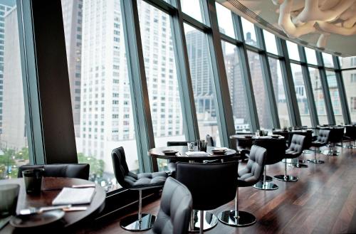 a restaurant with tables and chairs and large windows at Park Hyatt Chicago in Chicago