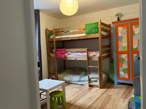 a room with two bunk beds and a table at Maison Sottou in Osse-en-Aspe