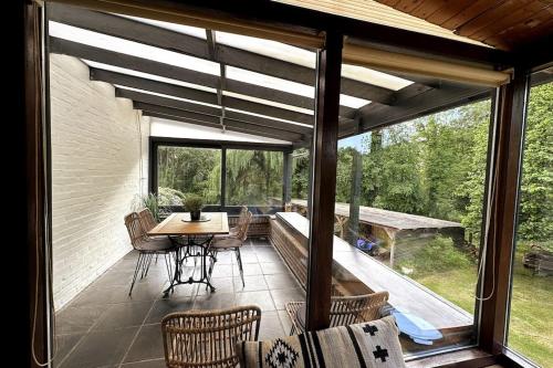 a screened in porch with a table and chairs at Vakantiewoning Hoogveld in Kortessem