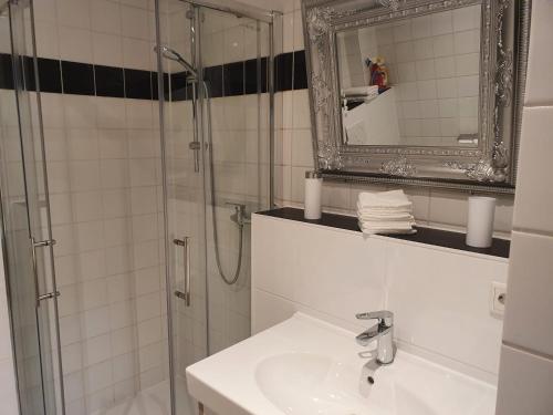 a bathroom with a sink and a shower with a mirror at Ferienwohnung/Montagewohnung in Paderborn