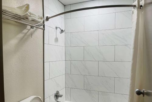 baño con ducha y puerta de cristal en Days Inn by Wyndham Killeen Fort Hood, en Killeen