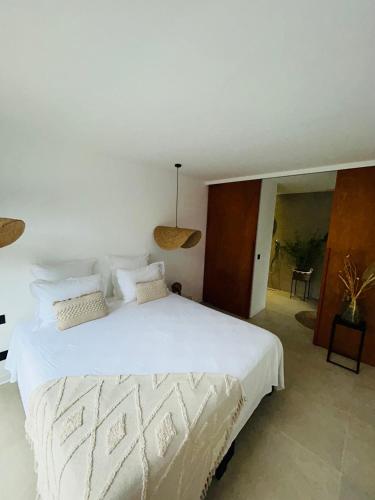a bedroom with a large white bed with white sheets at Tropical Lodges … Le Gosier in Le Gosier