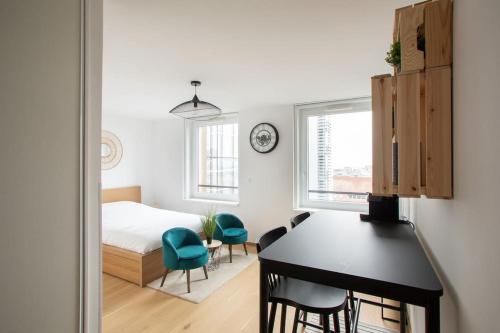 une chambre avec un lit, une table et des chaises dans l'établissement A L'Horizon - Joli Studio dans Strasbourg, à Strasbourg