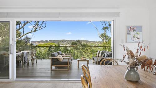 a dining room with a large sliding glass door at Tatala in North Avoca