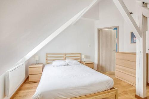 a bedroom with a white bed and a staircase at Le Bâle in Strasbourg