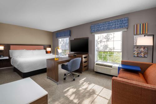 um quarto de hotel com uma cama e uma secretária com uma cama e uma secretária em Hampton Inn & Suites State College at Williamsburg Square em State College