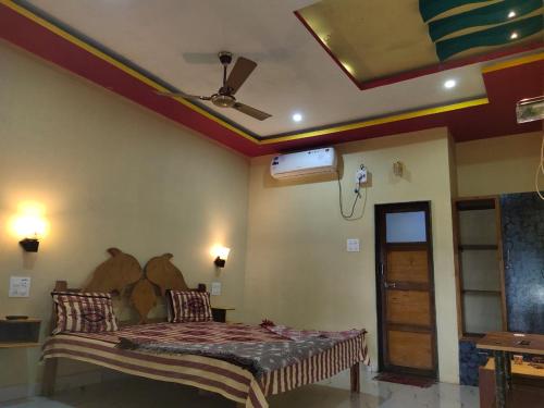 a bedroom with a bed and a ceiling fan at Vamoose Manali Beach Resort in Bhogwe